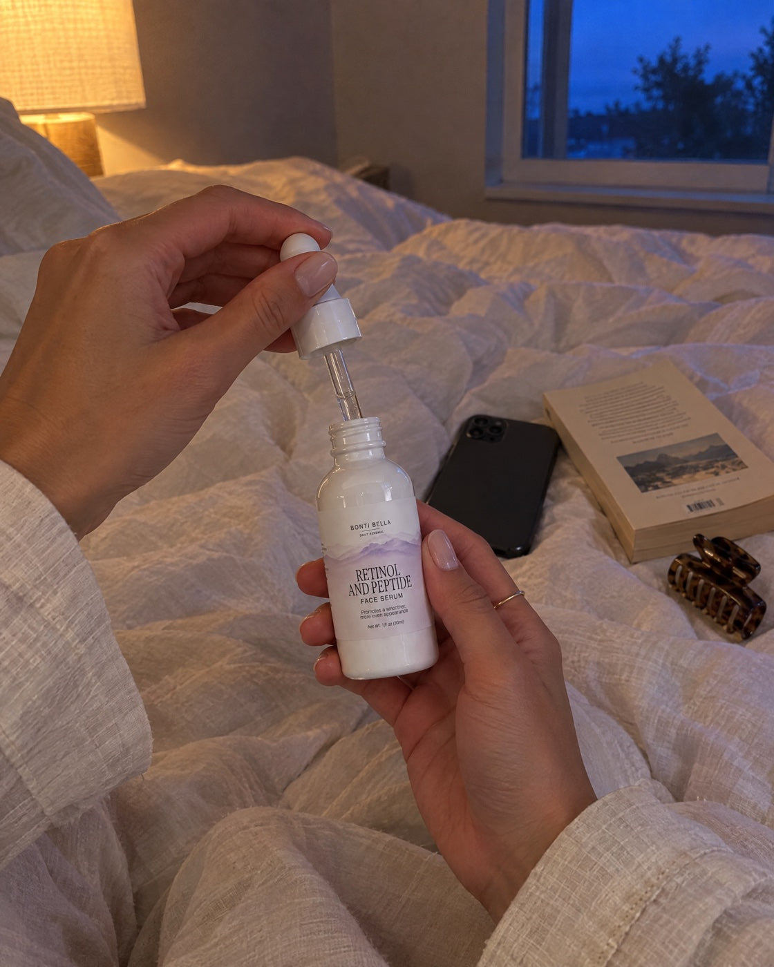 The Retinol and Peptide Face Serum on a bedside table in low evening light
